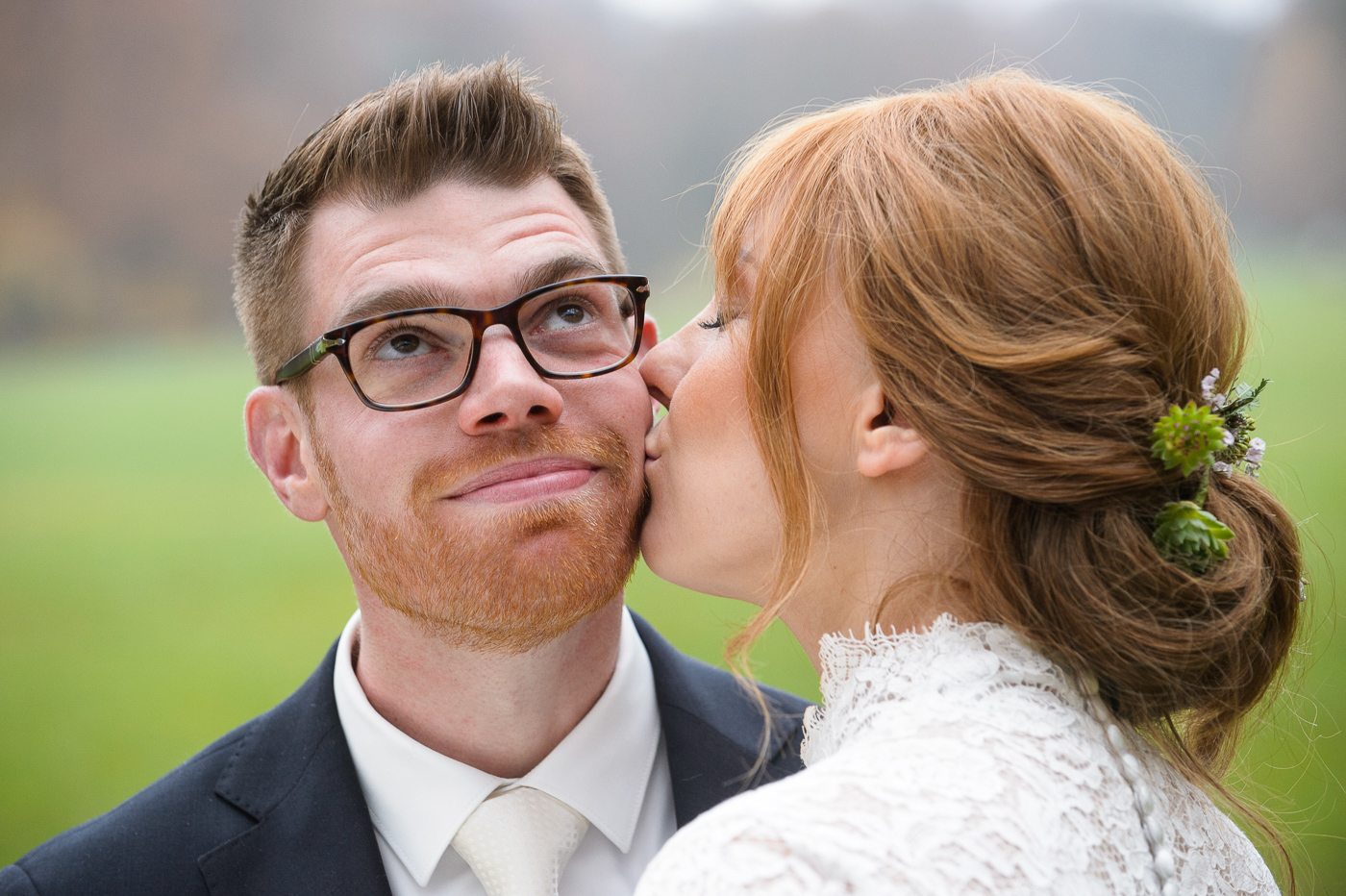Braut küsst Bräutigam im Englischen Garten