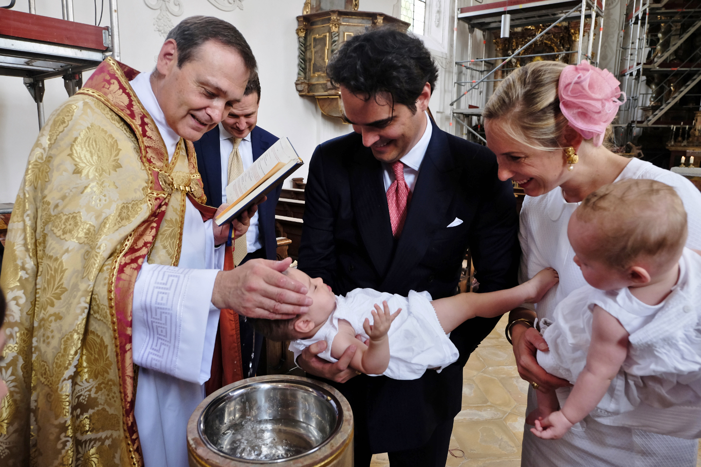 Familie während der Taufe in katholischer Kirche